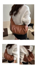 Detailed view of dark brown pleated leather shoulder bag with knotted strap design