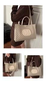Detail of trendy tote bag with M-letter monogram print and embossed circular logo
