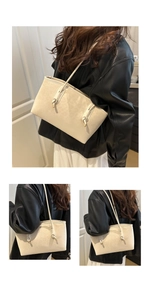 Detail of leopard embossed cream tote bag with knot strap and gold metal accents