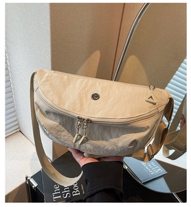Dettaglio borsa a mezzaluna in nylon beige con doppia zip e ampia tracolla in tessuto