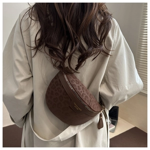 Détail d'un sac de poitrine à imprimé léopard porté sur un trench-coat beige élégant