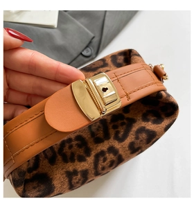 Détail du sac vintage léopard en daim avec poignée en cuir marron et fermoir doré chic