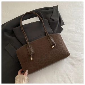 Detail showing brown leopard print texture on a large capacity tote bag with knot straps