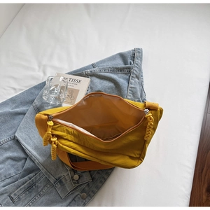 Detail view of bright yellow canvas shoulder bag showing spacious interior compartment