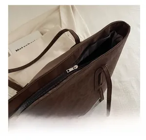 Detail view of smooth metal zipper closure on leopard print tote bag with nylon texture