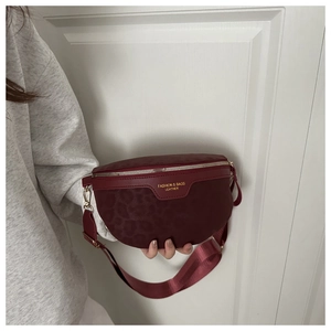 Détail de l'embossage léopard bordeaux et de la fermeture éclair dorée du sac