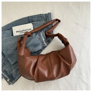 Detail of dark brown dumpling bag featuring textured PU leather and twisted knot handle