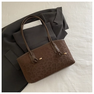 Detail of leopard print tote bag with stylish knot handle and gold metal accents