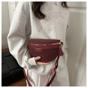 Détail du sac banane bordeaux en forme de croissant avec lettrage doré et sangle