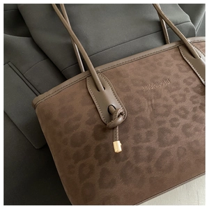 Close-up of leopard print tote bag with soft suede texture and leather knotted handle