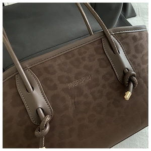 Detailed close-up of leopard print tote bag featuring knotted handles and gold accents