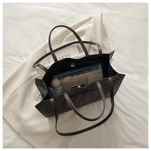 Detail showing spacious interior of brown monogram tote bag with tablet and essentials