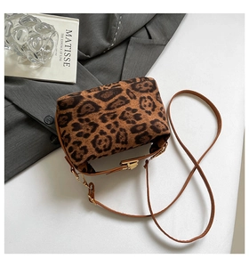 Détail du sac en peluche léopard avec bandoulière en cuir marron et boucle en métal doré
