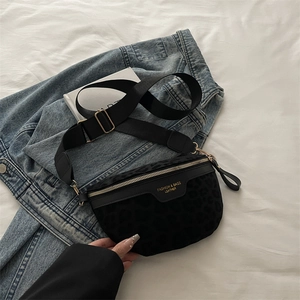 Sac bandoulière chic à motif léopard noir avec détails dorés sur fond de tissu blanc