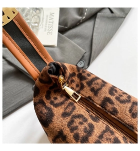 Détail du sac léopard avec fermeture éclair dorée et bandoulière en cuir bicolore
