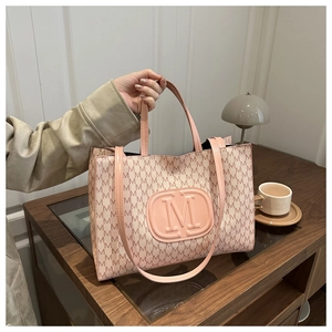 Detail of pink tote bag featuring embossed logo and all-over monogram letter print