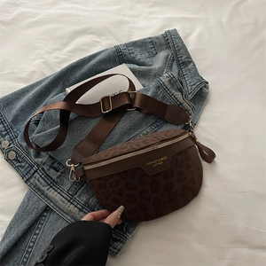 Sac bandoulière léopard marron avec large sangle posé sur une veste en jean bleu