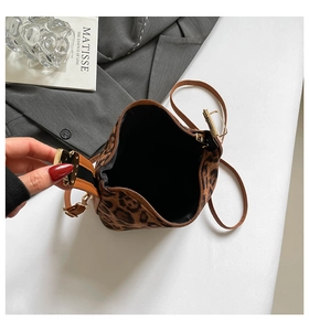 Gros plan détaillé d'un sac en daim léopard avec des finitions en métal doré