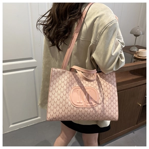 Detail of pink tote bag with monogram M pattern and embossed logo on shoulder strap