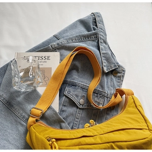 Detail of bright yellow nylon hobo bag featuring premium zippers and adjustable strap