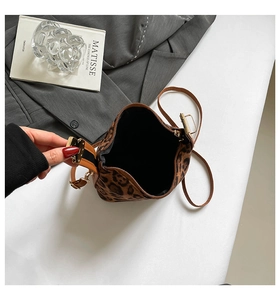 Détail du sac seau à imprimé léopard en fausse fourrure avec bandoulière en cuir marron