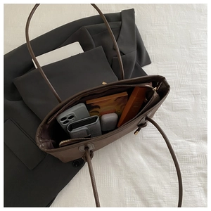 Detailed interior view of a brown leather tote bag showing spacious storage for daily items
