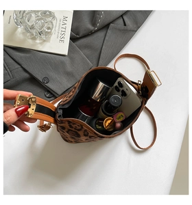 Vue de dessus du sac bandoulière léopard vintage montrant l'intérieur spacieux avec cosmétiques