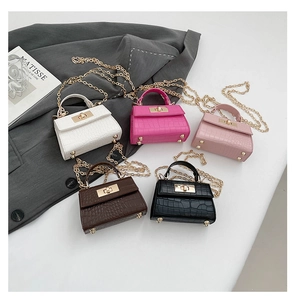 Detail of mini faux crocodile leather handbags with metal chain straps and turn-lock closure