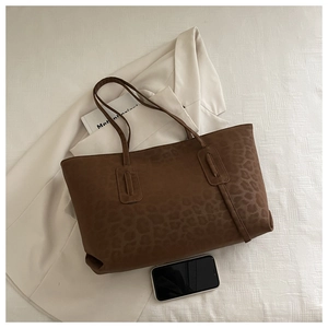 Detail of soft leopard print tote bag with plush texture on a white background