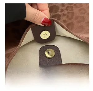 Detail showing high-quality gold magnetic snap closure on leopard print tote bag