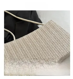 Macro shot of beige woven handbag detail featuring a sharp herringbone knit pattern