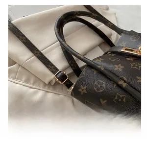 Close-up of golden adjustable buckle and retro monogram canvas on stylish tote bag