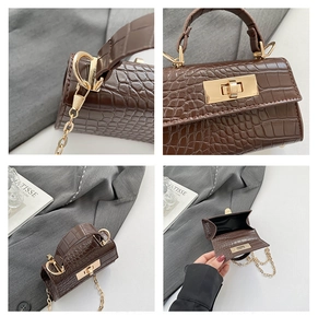 Detail view of brown crocodile texture handbag with gold twist lock and interior storage