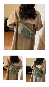 Dettaglio della borsa a mezzaluna in nylon verde pisello con doppia cerniera e tiranti