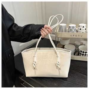 Detail of off-white leopard pattern tote bag with knotted strap and metal hardware