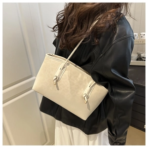 Detail view of large cream leopard print tote bag with stylish knot strap and gold accents