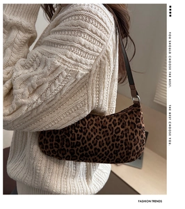 Detail of vintage leopard print underarm bag in soft textured fabric with leather strap