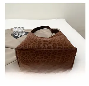Detail view showing the wide wear-resistant bottom and leopard print texture of the tote bag