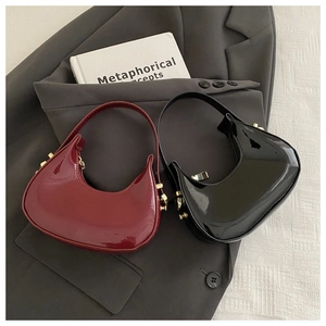 Close-up of crescent mini bags in burgundy and black patent leather with gold hardware