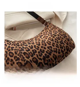 Detail of leopard print suede baguette bag with leather strap and metal buckle