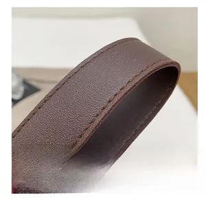 Detail of premium brown lychee pattern leather shoulder strap with reinforced stitching