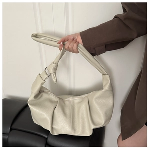 Macro detail of creamy moon bag showing lychee grain texture and knot shoulder strap