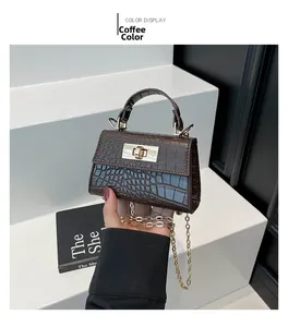 Detail of coffee brown crocodile pattern mini bag with gold hardware and chain strap