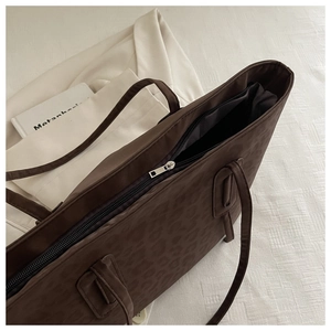 Detailed view of dark brown leopard print tote with zipper and chic canvas texture