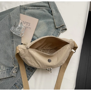 Dettaglio della borsa a tracolla in nylon beige con cinghia larga e interno ampio