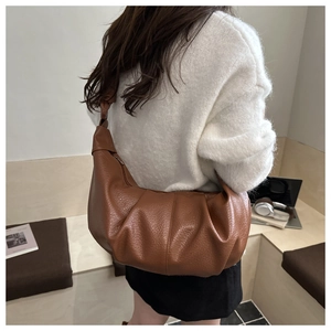 Detail of soft brown pleated hobo bag with textured faux leather and knotted strap