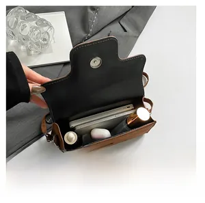 Interior view showing the large capacity of this brown leather crossbody bag with daily items