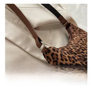 Close-up of leopard print baguette bag with silver ring buckle and brown leather strap