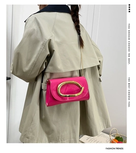 Chic rose pink patent leather crossbody bag with a large golden U-shaped buckle detail