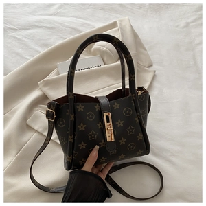Detail of printed tote bag with star patterns and a gold metal vertical lock closure